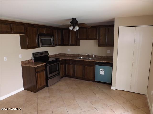 6520 West Berkeley Road Phoenix, AZ 85035 - Photo 3 of 22 a kitchen with stainless steel appliances granite countertop a stove a refrigerator and a sink