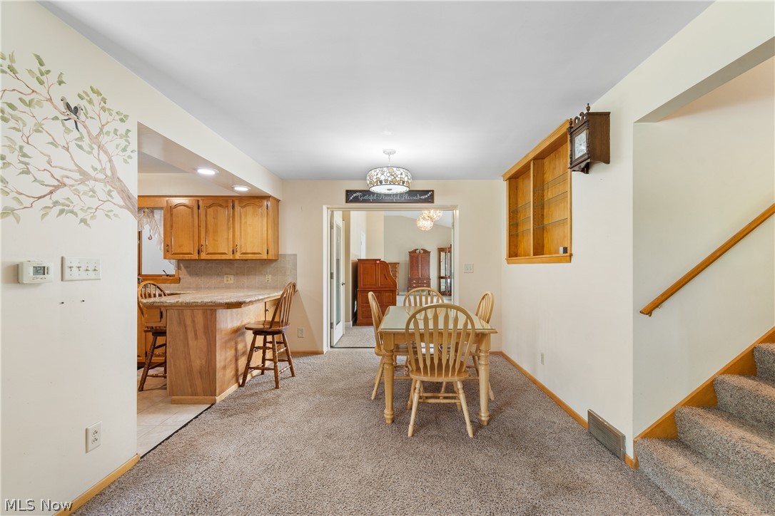 22840 Buck Road Alliance, OH 44601 - Photo 7 of 36 Dining area featuring light carpet and suspended lighting