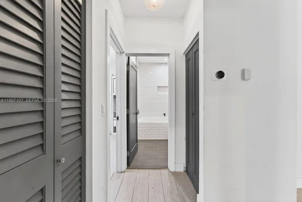 a view of a hallway with wooden floor and closet