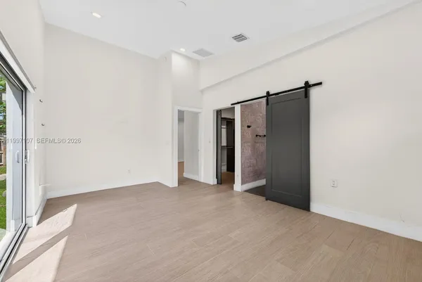 an empty room with closet and a hallway