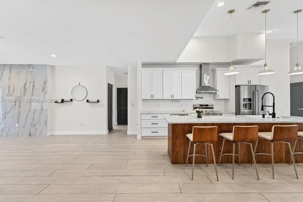 a kitchen with stainless steel appliances a sink a stove a refrigerator and cabinets