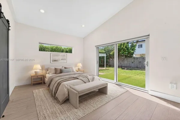 a bedroom with a bed and a large window