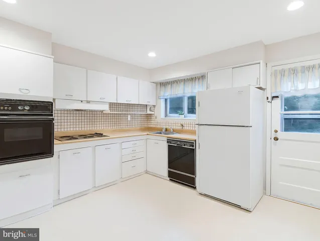 a kitchen with cabinets stainless steel appliances and a refrigerator