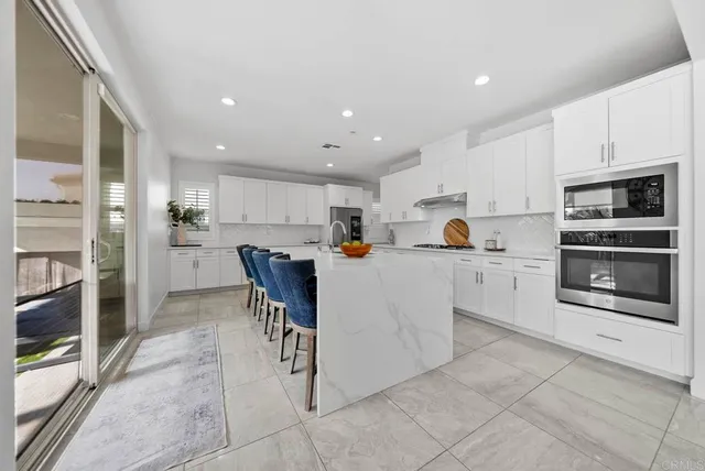 a kitchen with a white counter top space cabinets and stainless steel appliances