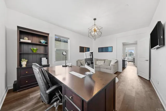 a view of a dining room with furniture a chandelier and wooden floor