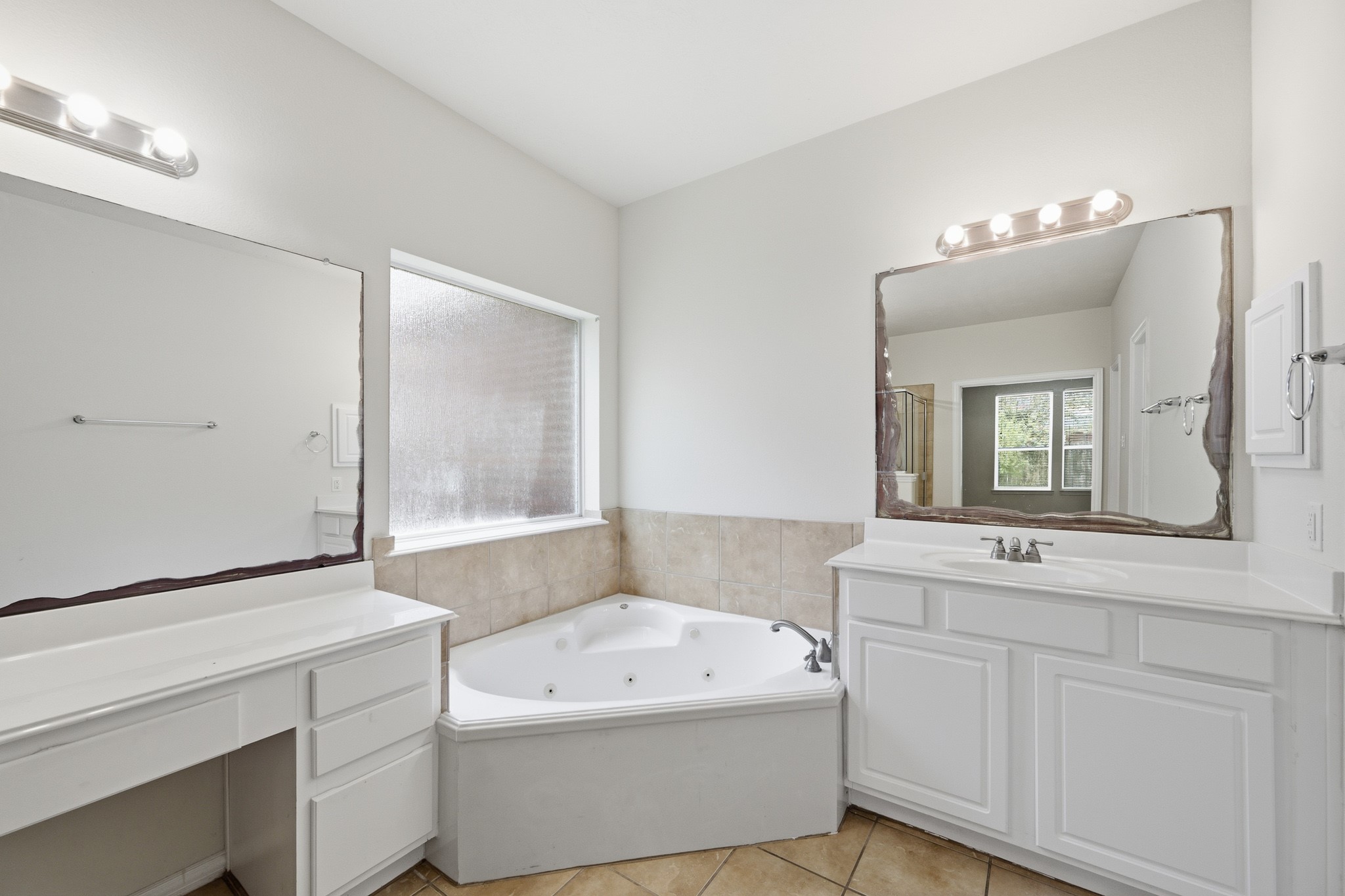 2117 Rushing Spring Drive Pearland, TX 77584 - Photo 24 of 42 Experience relaxation in this elegant primary bathroom, featuring a luxurious corner soaking tub and dual vanities, all bathed in natural light.
