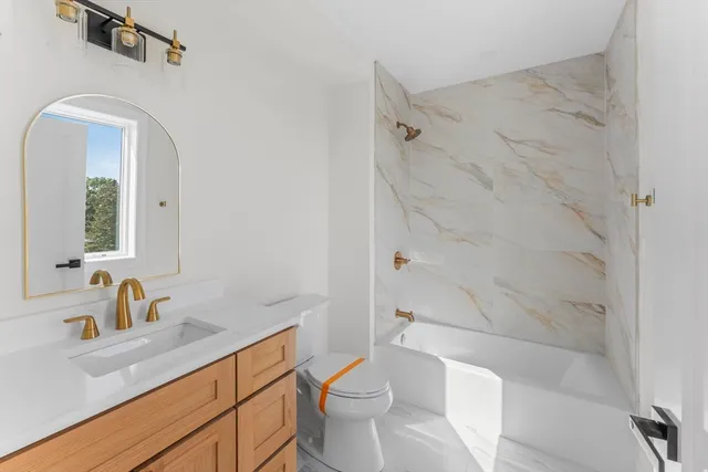 a bathroom with a sink a toilet and shower