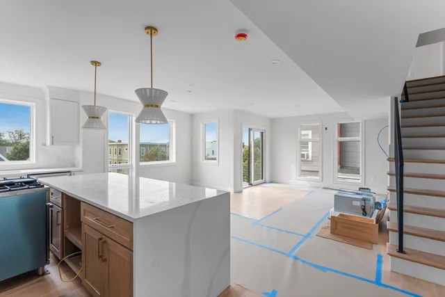 a large kitchen with kitchen island a counter space a sink appliances and a living room view