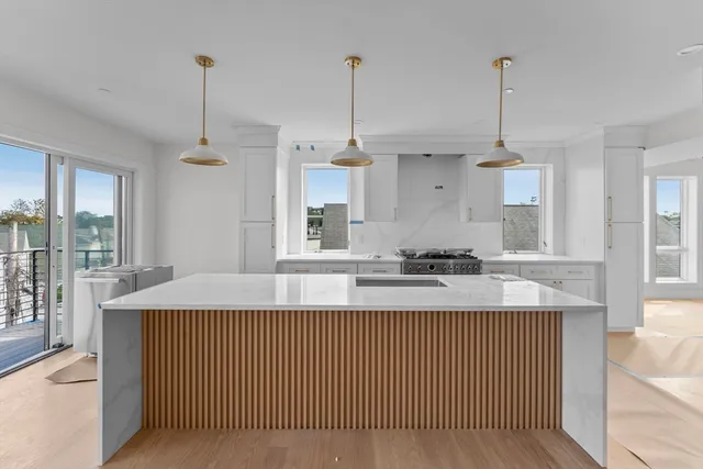 a kitchen with kitchen island granite countertop a sink a counter top space and living room view