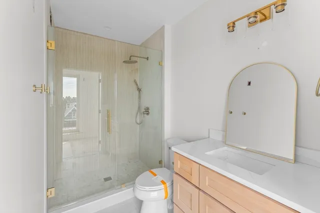a bathroom with a granite countertop sink a toilet and shower