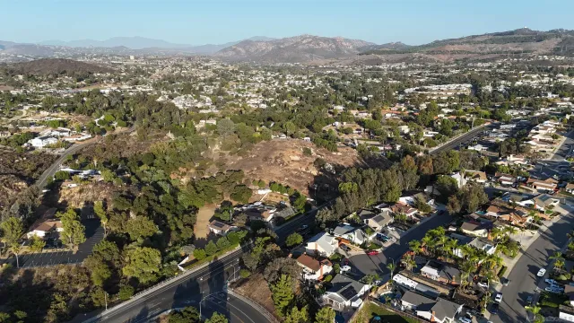 an aerial view of residential houses with outdoor space and trees