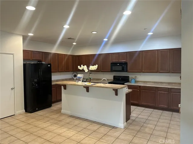 a kitchen with stainless steel appliances granite countertop a refrigerator and a stove