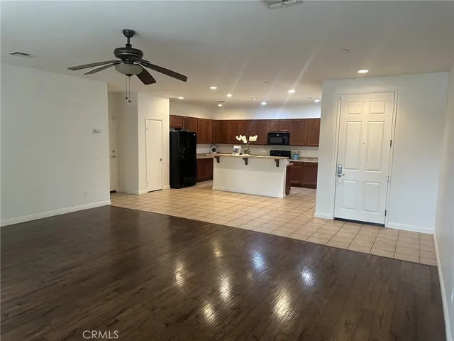 a view of a living room and kitchen with wooden floor