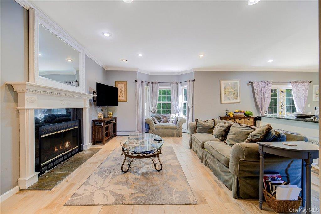 104 Wiccopee Road Putnam Valley, NY 10579 - Photo 10 of 50 Open-concept family room space with light wood-finish flooring, recessed lighting, and a white mantel fireplace with a stone hearth