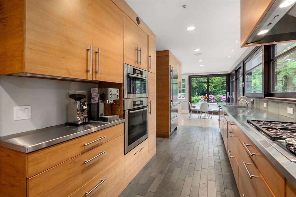 244 Heath Street Brookline, MA 02467 - Photo 6 of 36 a kitchen with stainless steel appliances granite countertop a stove top oven a sink dishwasher a refrigerator and cabinets with wooden floor