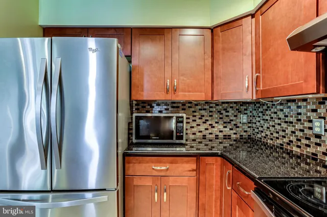 a kitchen with stainless steel appliances granite countertop a refrigerator and a sink