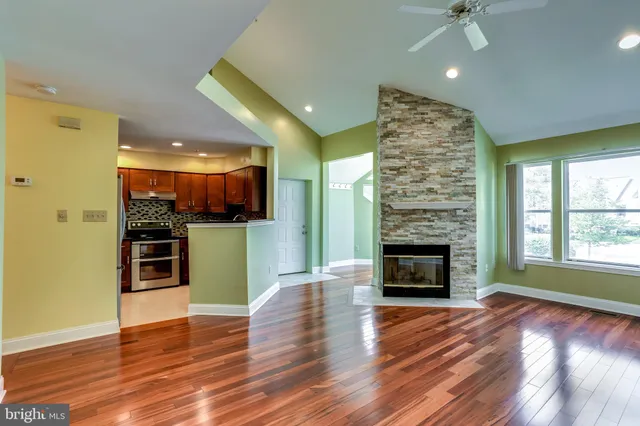 an empty room with wooden floor a fireplace and a window