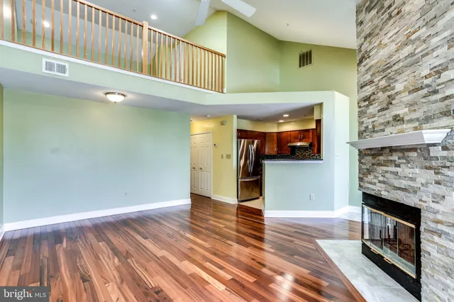 a view of a livingroom with wooden floor and a fireplace