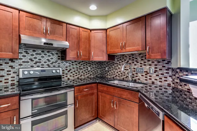 a kitchen with granite countertop wooden cabinets and black appliances