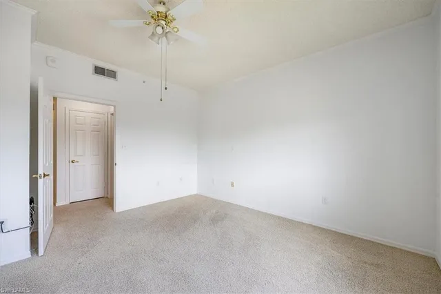 an empty room with a ceiling fan and a window