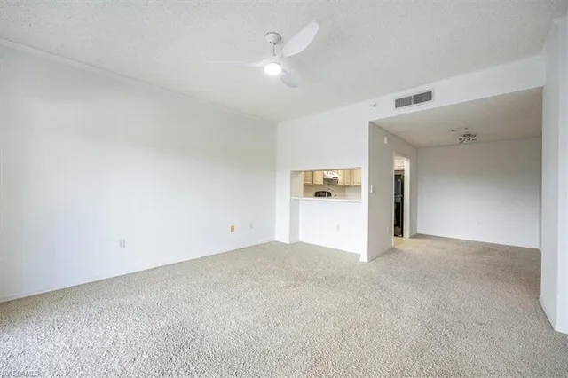 a view of empty room with kitchen