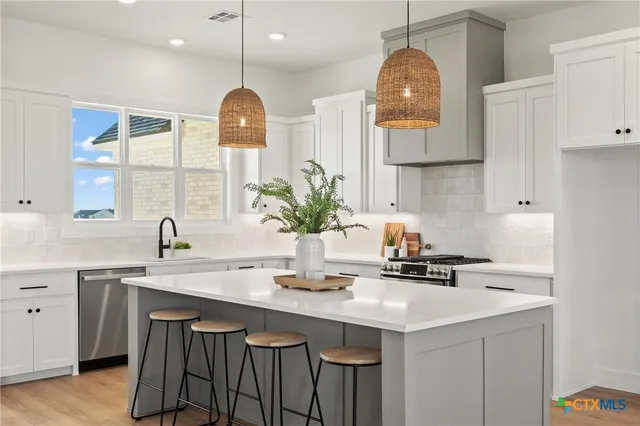 a kitchen with a sink cabinets and wooden floor