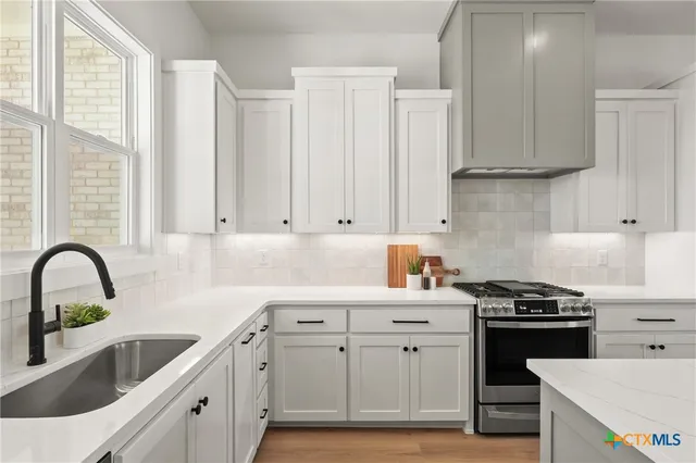 a kitchen with white cabinets and white appliances