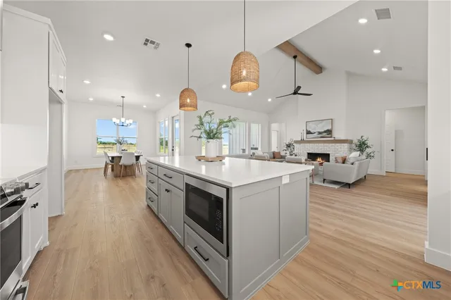 a kitchen with a stove cabinets and wooden floor