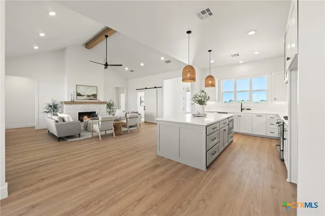 a large white kitchen with lots of counter space and a wooden floors
