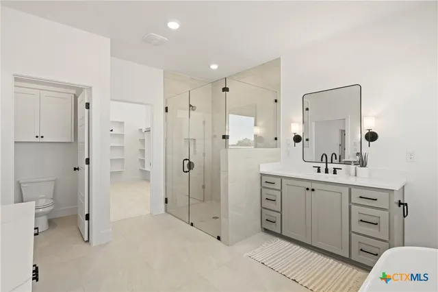 a spacious bathroom with a shower sink and a mirror