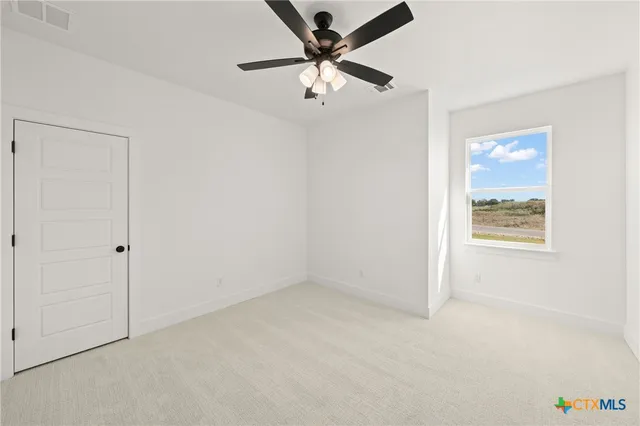 an empty room with a window and a fan