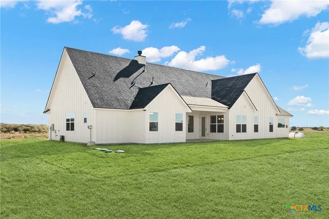 a view of a house with a yard and potted plants