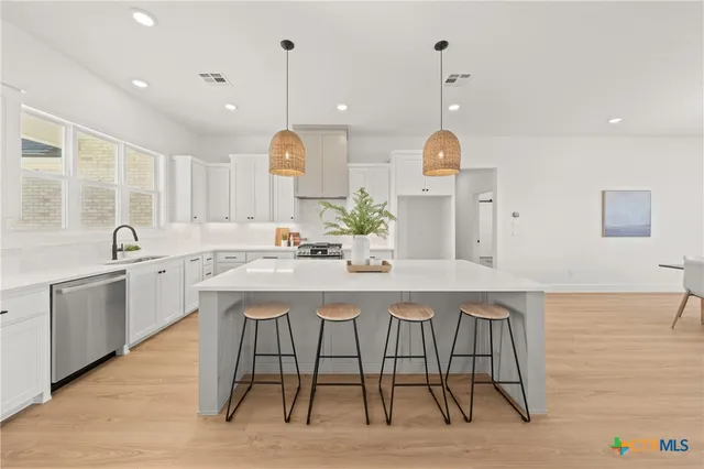 a kitchen with a table chairs sink and cabinets