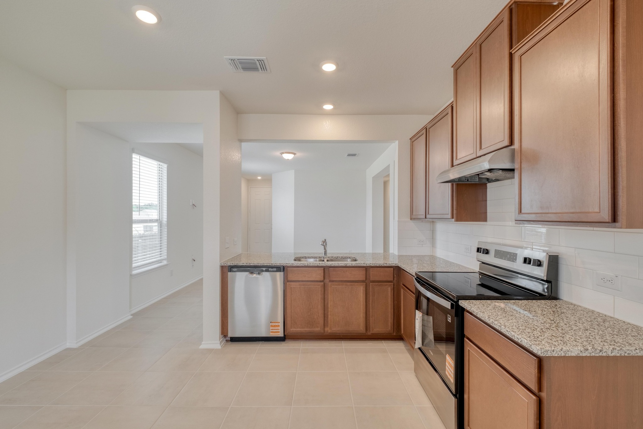 280 Feathers Street Jarrell, TX 76537 - Photo 12 of 28 a kitchen with stainless steel appliances granite countertop a sink stove and cabinets