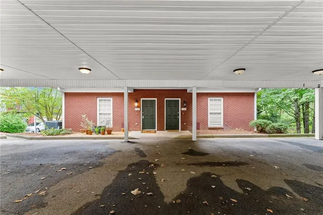 a front view of a house with lots of trees and plants