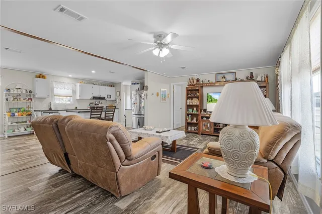 a living room with furniture and a dining table with kitchen view