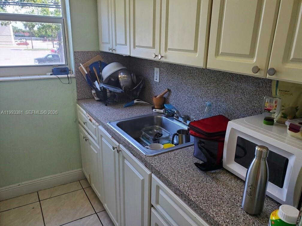 3901 Southwest 78th Court, Unit 221 Miami, FL 33155 - Photo 9 of 13 a kitchen with sink cabinets and window