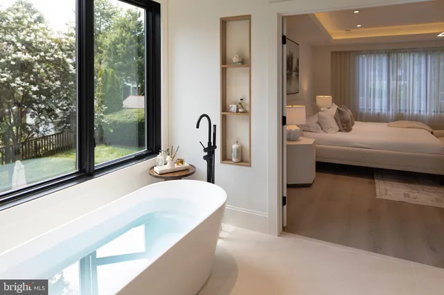 a bedroom with a bed lamp and a large window