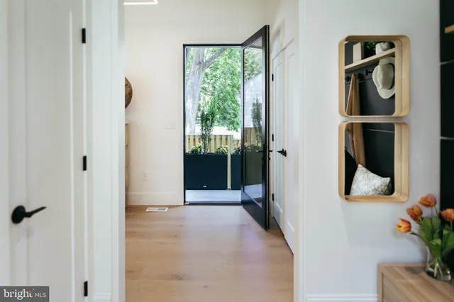 a view of a hallway with wooden floor and a potted plant