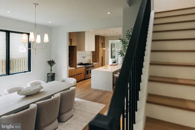 a living room with furniture kitchen view and a large window