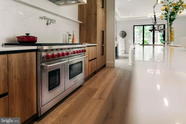 a kitchen with stove and wooden floor