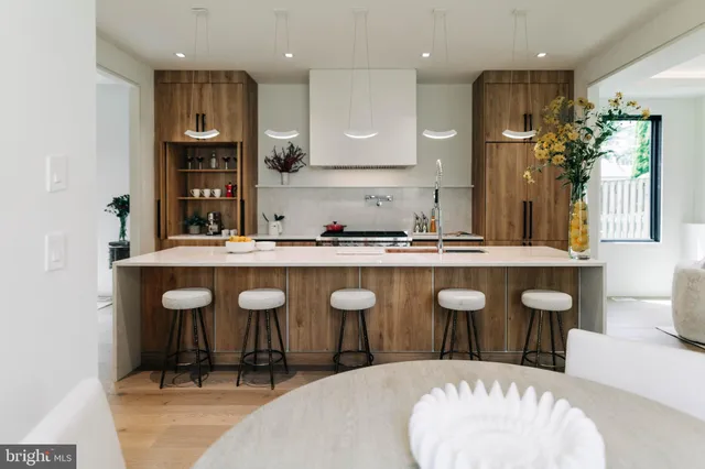 a large kitchen with granite countertop a white table and chairs in it