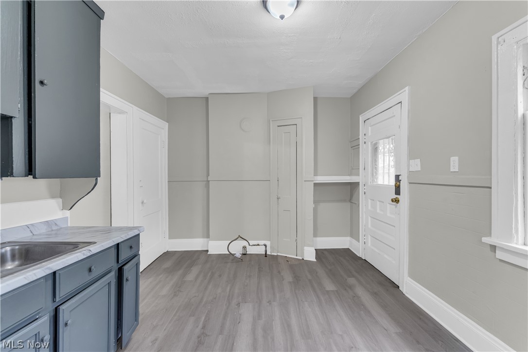 1144 East 145th Street, Unit 1/RIGHT Cleveland, OH 44110 - Photo 11 of 20 Kitchen area featuring gray wood-finish flooring, white baseboards, and light gray wall paint
