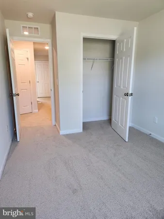 an empty room with a bench and a cabinet
