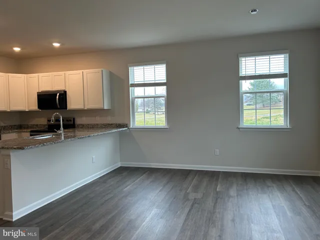 a view of a kitchen that shows a sink wooden floor and a window