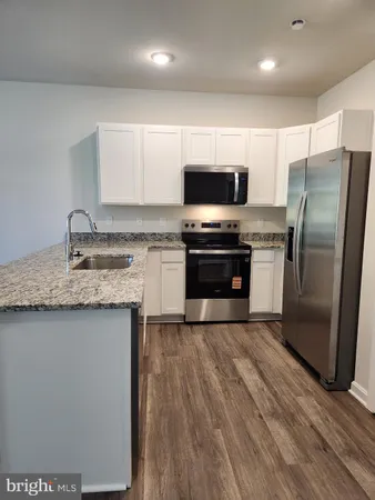 a kitchen with stainless steel appliances a sink stove microwave and refrigerator