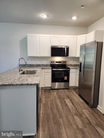 a kitchen with stainless steel appliances a sink stove microwave and refrigerator