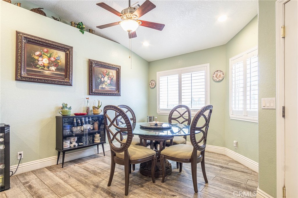 9735 Elsinore Road Oak Hills, CA 92344 - Photo 11 of 64 a dining room with furniture a window and a chandelier