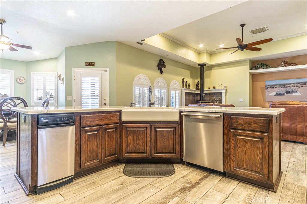 9735 Elsinore Road Oak Hills, CA 92344 - Photo 14 of 64 a large white kitchen with a sink and dishwasher a stove with wooden floor