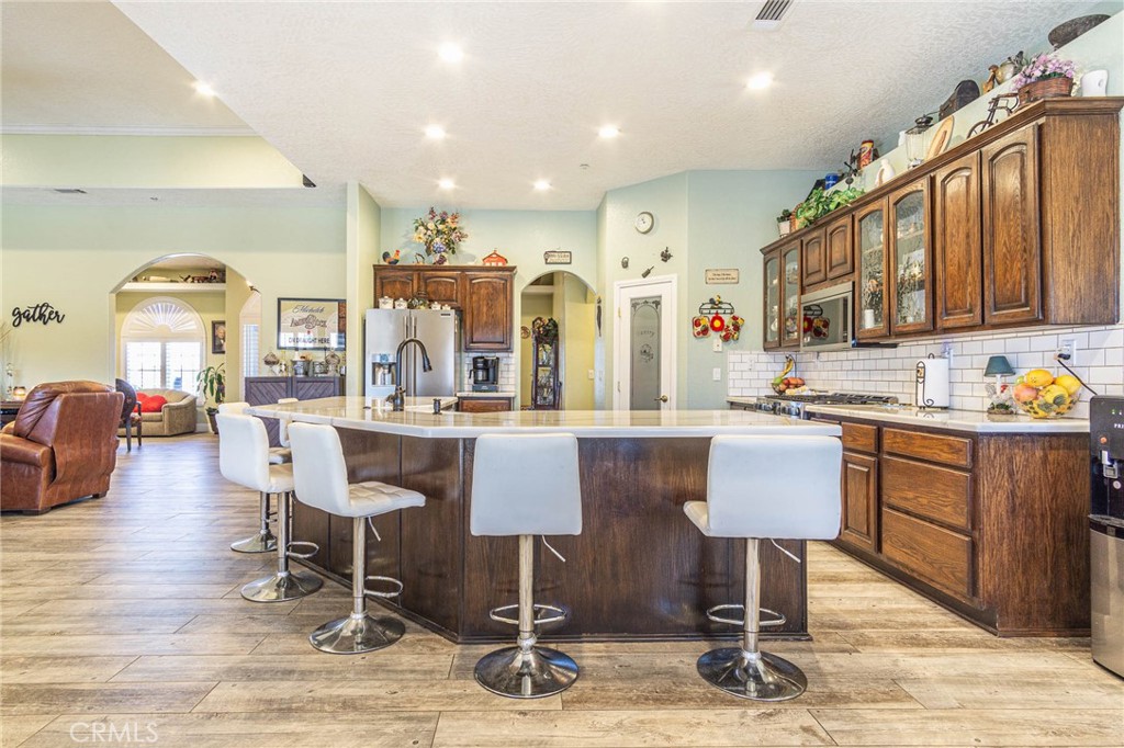 9735 Elsinore Road Oak Hills, CA 92344 - Photo 15 of 64 a dinning room with kitchen island furniture a fireplace and a sink